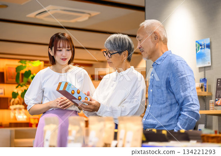 一位店員和一對老年夫婦正在挑選紀念品 134221293