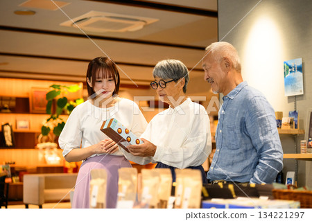 一位店員和一對夫婦正在挑選紀念品 134221297