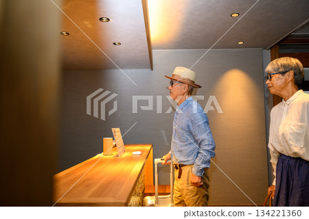 Senior couple checking in at hotel reception 134221360