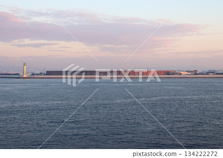 The Osaka Expo's large roof ring and Osaka Lighthouse seen from the sea side in the morning glow 134222272