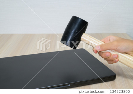 A hammer and recording media being swung down on a laptop 134223800
