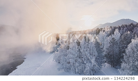 Winter landscape with fog and sun rising over snowy trees and mountains in a natural setting at dawn. High quality photo Winter landscape with fog and sun rising over snowy trees and mountains in a natural setting at dawn. High quality photo 134224298
