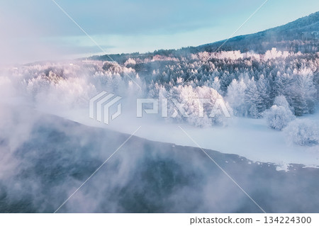 Krasnoyarsk, Siberia shows a snowy landscape filled with trees and mist around New Year. The scene illustrates the beauty of winter and cold weather in Russia. High quality photo 134224300