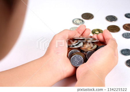 Child's hand holding coins 134225522