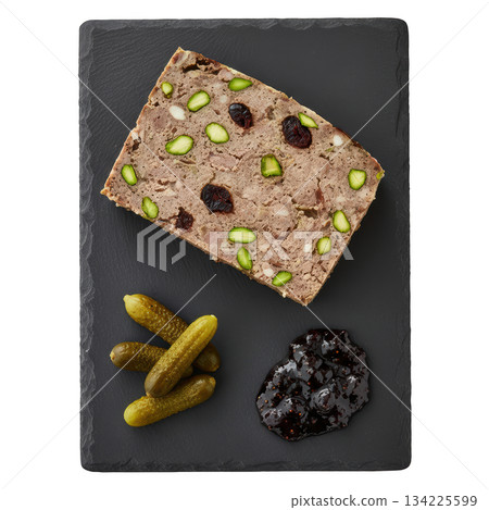 Savory country pate with pistachio, fig jam, and cornichon. delicious French appetizer on dark slate platter 134225599