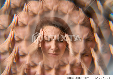Woman suffering from headache holding her head with multiple exposure effect Woman suffering from headache holding her head with multiple exposure effect 134226294