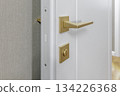 Golden Door Handle and Lock on White Interior Door in Modern Apartment 134226368