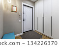 Modern Hallway with White Entrance Door and Built-in Wardrobe in Apartment Interior 134226370