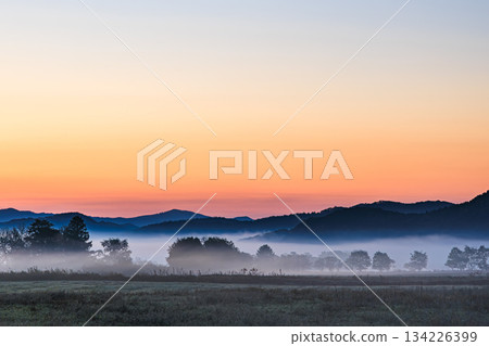 A peaceful moment among the mountains and grasslands bathed in morning mist 134226399