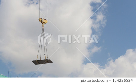 A crane lifting heavy equipments on a construction site - in front of blue sky 134226524