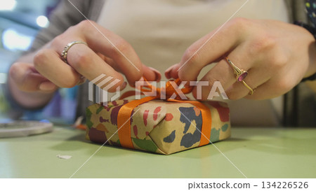 Wrapping gift - close up view woman's hands Wrapping gift - close up view woman's hands 134226526