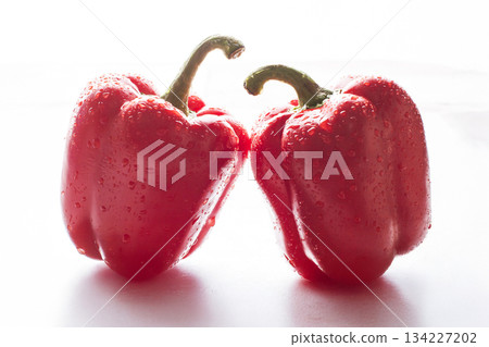 two red peppers in the water droplets on white background. 134227202