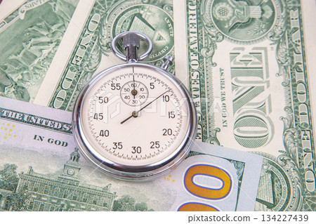 mechanical stopwatch on the background of dollars mechanical stopwatch on the background of dollars 134227439