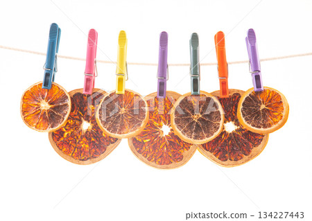dried pieces of different citrus fruits hang on colored clothespins dried pieces of different citrus fruits hang on colored clothespins 134227443