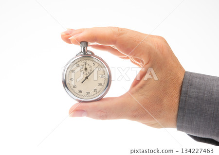 hand with a mechanical analog stopwatch on a white background hand with a mechanical analog stopwatch on a white background 134227463