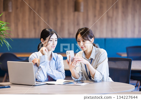 Business woman using a smartphone in the office Business woman using a smartphone in the office 134227644