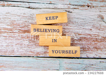 Wooden blocks stack together to form an uplifting message encouraging everyone to keep believing in themselves. The natural texture of the wood adds warmth to the messages significance Wooden blocks stack together to form an uplifting message encouraging everyone to keep believing in themselves. The natural texture of the wood adds warmth to the messages significance 134227688