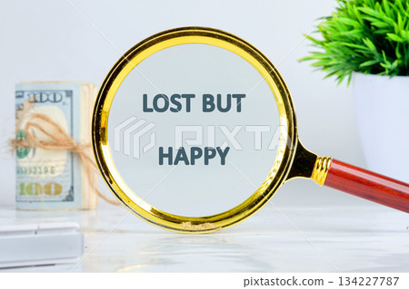 A magnifying glass highlights the words lost but happy, symbolizing joy in the midst of uncertainty 134227787