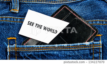 A black wallet peeks from a blue denim pocket, featuring a card that reads SEE THE WORLD. The vibrant colors highlight the call to adventure and exploration in everyday life 134227870