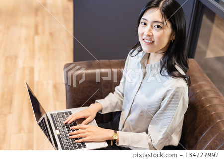 一個女人和一台筆記本電腦一起工作 134227992