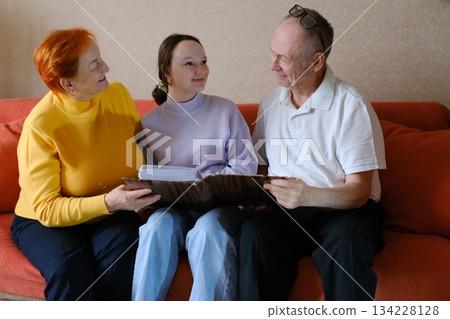 Grandfather and granddaughter went to a restaurant, meeting grandfather, grandmother and a teenage girl, walking together, socializing 134228128