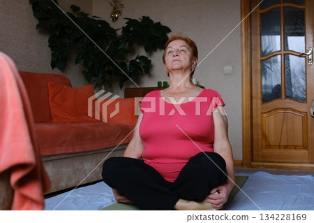 old woman doing exercises at home in the morning Elderly woman doing exercise at home. Healthy leisure old woman doing exercises at home in the morning Elderly woman doing exercise at home. Healthy leisure 134228169