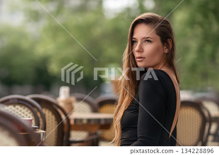 Woman Portrait Cafe, pensive model sits at outdoor table on a daytime cafe break. Woman Portrait Cafe, pensive model sits at outdoor table on a daytime cafe break. 134228896