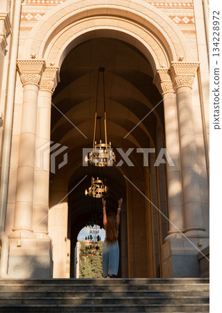 Chandelier Entrance Church Building, a person stands under a chandelier in a church entrance. Chandelier Entrance Church Building, a person stands under a chandelier in a church entrance. 134228972