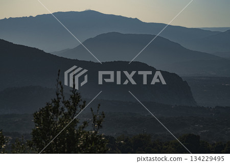 foggy mysterious bluish mountains in the distance. Layers of mountains in Sardinia in Italy at the sunset. foggy mysterious bluish mountains in the distance. Layers of mountains in Sardinia in Italy at the sunset. 134229495