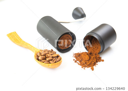 A modern manual coffee grinder, opened to show ground coffee 134229640