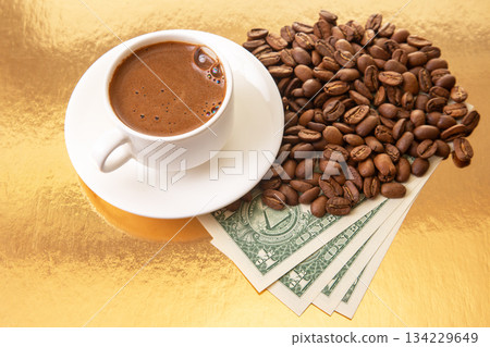 Rich Turkish coffee in a white cup is featured with coffee beans and dollar bills Rich Turkish coffee in a white cup is featured with coffee beans and dollar bills 134229649
