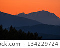 Sunrise over misty mountain layers creates a peaceful, landscape in warm morning light. 134229724