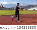 Senior woman running on stadium track 134229835