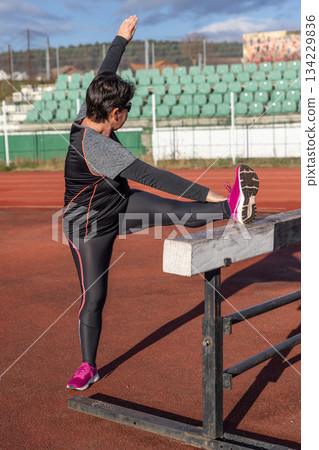 Woman stretching leg Woman stretching leg 134229836