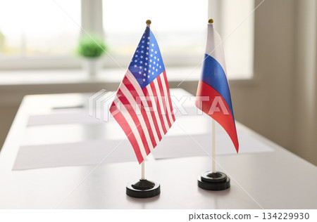 US and Russia mini desk flags showcasing diplomacy on conference negotiation table US and Russia mini desk flags showcasing diplomacy on conference negotiation table 134229930