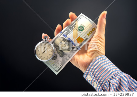 mechanical stopwatch and dollars in man hand. Part time accuracy for business mechanical stopwatch and dollars in man hand. Part time accuracy for business 134229957