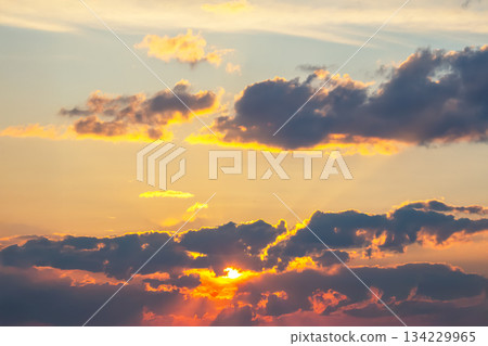 Dynamic sky with towering dark clouds and brilliant sunlight rays cutting through Dynamic sky with towering dark clouds and brilliant sunlight rays cutting through 134229965