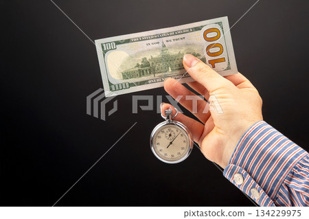 mechanical stopwatch and dollars in man hand. Part time accuracy for business. mechanical stopwatch and dollars in man hand. Part time accuracy for business. 134229975