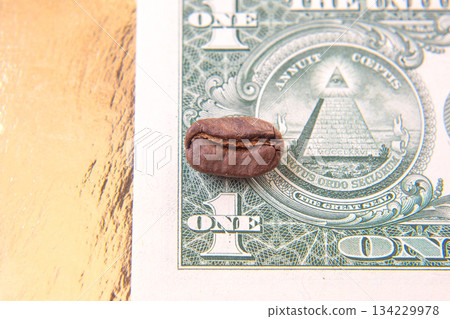 Detailed shot of a cracked coffee bean placed on a one-dollar bill, Detailed shot of a cracked coffee bean placed on a one-dollar bill, 134229978