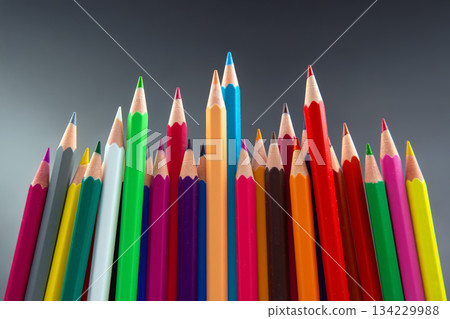 Colorful pencils arranged in a wave-like pattern, showcasing a spectrum of hues 134229988