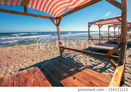 Seascape in the evening. Wooden sun gazebo on the beach. Minimalist landscape 134231223