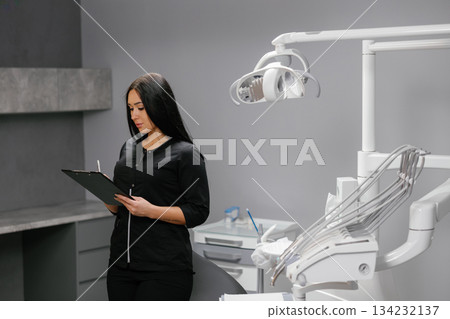 Woman dentist updating patients medical records 134232137
