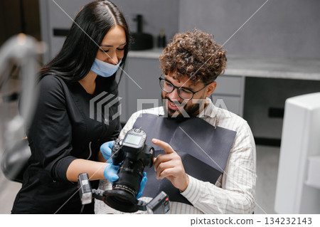 Patient viewing oral photography results with dentist in clinic Patient viewing oral photography results with dentist in clinic 134232143
