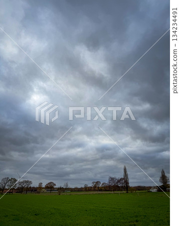 Rijkevorsel, Antwerpse Kempen, Belgium, Gloomy clouds over open field and distant church steeple Rijkevorsel, Antwerpse Kempen, Belgium, Gloomy clouds over open field and distant church steeple 134234491