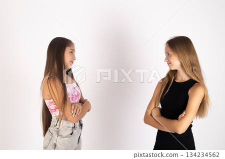 Two teenage girls standing and looking away from each other in studio 134234562