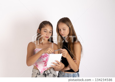 Two teenage girls sharing popcorn and enjoying a movie time moment 134234586