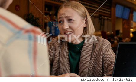 Happy young woman smiling and talking to a partner in a coffee shop 134234623