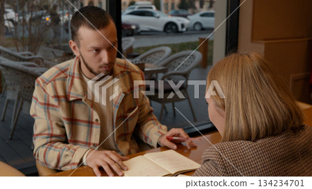 Young man talking and explaining a concept to his partner in a cafe Young man talking and explaining a concept to his partner in a cafe 134234701