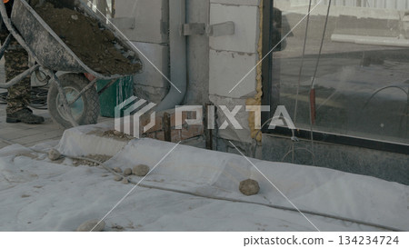 Construction worker on building site using a smartphone to communicate Construction worker on building site using a smartphone to communicate 134234724