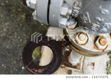 Rusty pipe with a bolt on it 134235076